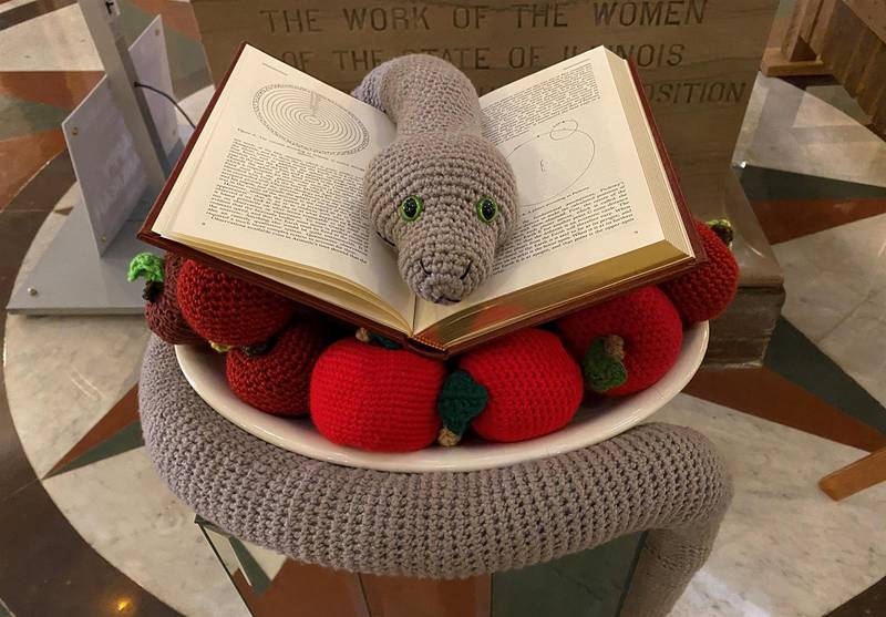 The Satanic Temple of Illinois' 2022 holiday display is pictured on the Illinois Capitol rotunda. It consists of a crocheted snake sitting on a book and a pile of apples crocheted by Temple members. (Capitol News Illinois photo by Jerry Nowicki)