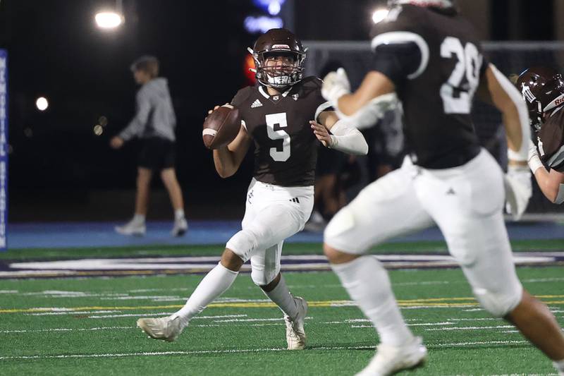 Joliet Catholic’s Andres Munoz rolls out to pass against Providence on Friday, Sept. 1, 2023 Joliet Memorial Stadium.