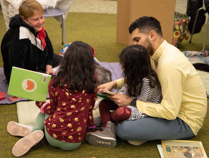 The Khan family reads to therapy dog Regal at the Elmhurst Public Library on Saturday, Feb. 11, 2023.