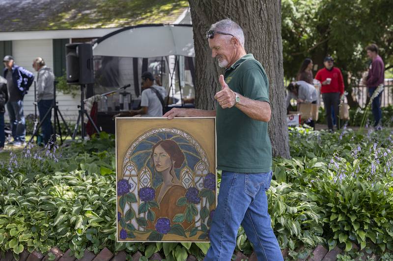 Dan Burke gives the thumbs up after procuring a new piece of art by Oregon artist Linda Magklaris Sunday, Sept. 7, 2025 at the Grand Detour Arts Festival.