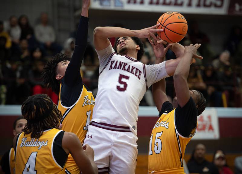 Kankakee's EJ Hazelett, center, is fouled as Richards's Ethan Morris, left, and Paul Rayon V, right, guard in the Kankakee Holiday Tournament at Kankakee High School on Saturday, December 27, 2025.
