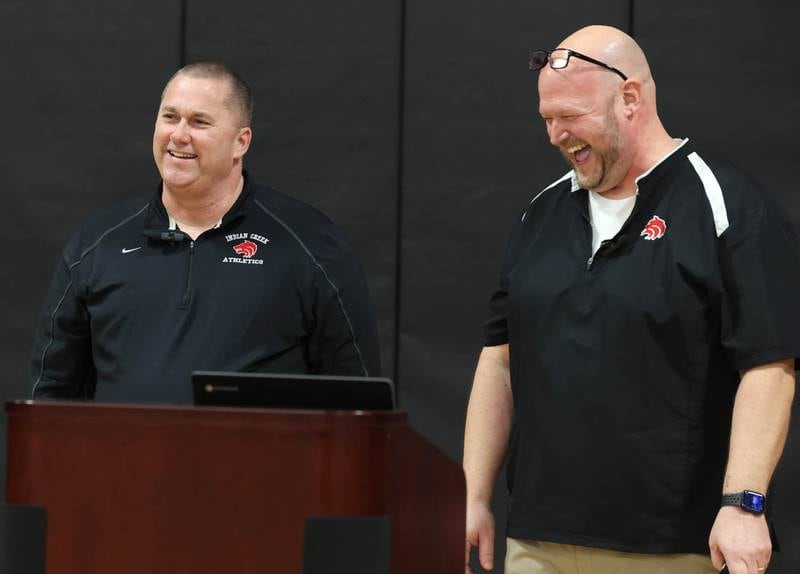 Indian Creek girls basketball head coach Paul Muchmore and athletic director Ehren Mertz share a laugh Tuesday, Feb. 10, 2026, during a cermony held before Indian Creek took on Rosary. Muchmore, the longtime coach of the Timberwolves, was being honored at his last home game before retirement from coaching at the end of the season.