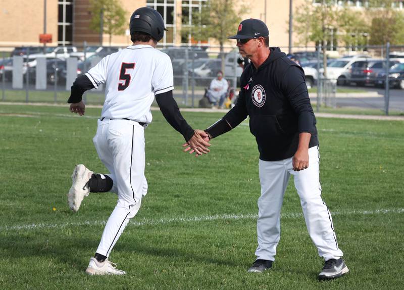 DeKalb's Cole Latimer is congratulated by head coach head coach Josh Latimer after homering during their game against Neuqua Valley Tuesday, May 7, 2024, at DeKalb High School.