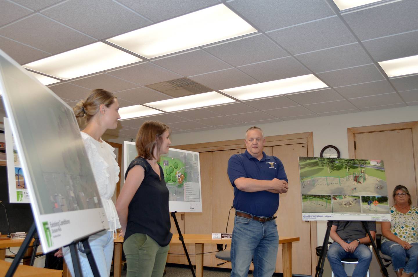 Village of Mt. Morris Parks and Recreation Trustee Jim Hopkins, right, and Hitchcock Design Group Senior Associate Monica Goshorn-Maroney, center, and Junior Associate Abby Mies, left, talk to about 40 residents about a proposed redevelopment of Zickuhr Park utilizing an Illinois Department of Natural Resources OSLAD grant during an Aug. 1, 2023, community meeting.