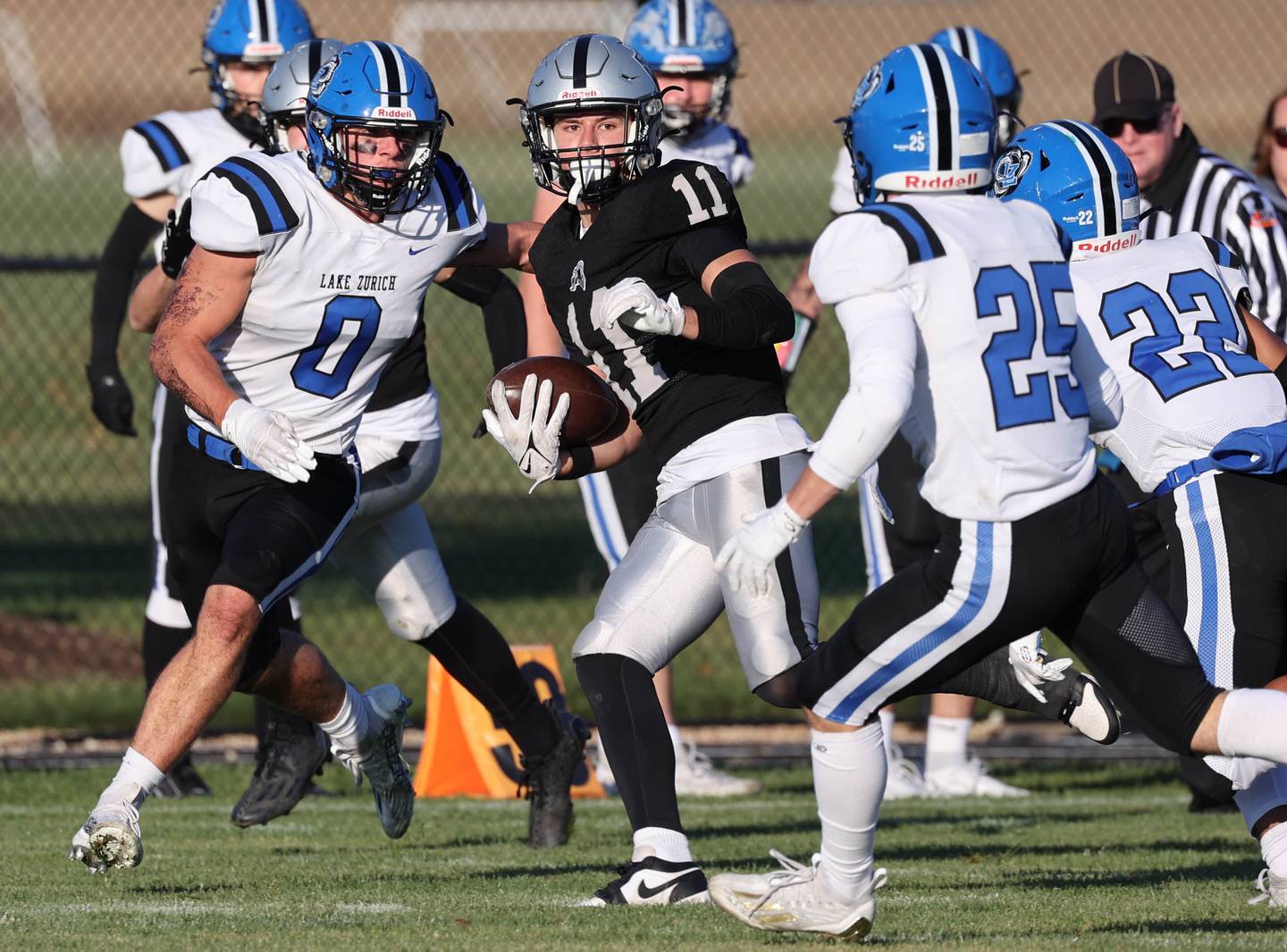 Kaneland's Dominick DeBlasio runs between Lake Zurich's Lincoln Adams (left) and Owen Peshek Saturday, Nov. 4, 2023, during their Class 6A second round playoff game at Kaneland High School in Maple Park.