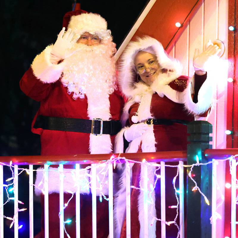 Santa and Mrs Claus wave to their fans as they get ready to head into his house at the corner of West State and North Maple Streets Friday, Dec. 6, 2024, during the Sycamore Chamber of Commerce’s Walk With Santa in downtown Sycamore.