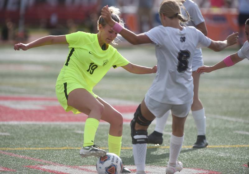 Richmond-Burton's Layne Frericks (19) controls the ball near Quincy Notre Dame's Anna Keck during Saturday’s IHSA Class 1A state girls soccer championship game at North Central College in Naperville.