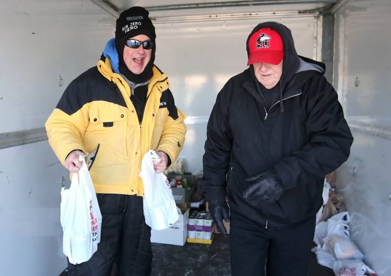 WLBK Radio host TD Ryan (left) and former DeKalb alderman Bill Finucane put more food in the donations trailer Thursday, Dec. 5, 2024, during Freezin’ For Food in the Hy-Vee parking lot off of DeKalb Avenue in Sycamore. WLBK’s Freezin’ For Food collects non-perishable food items and monetary donations to help restock The Salvation Army’s food pantries in DeKalb County.