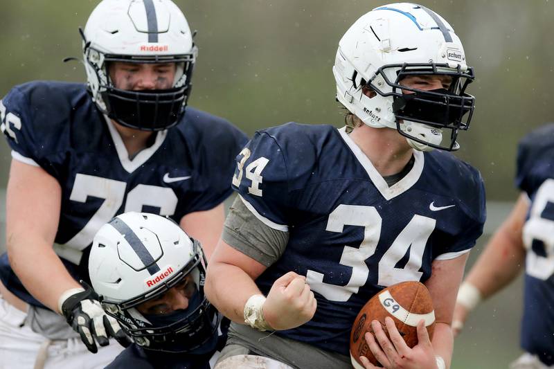Cary-Grove's Nicholas Hissong (from front) celebrates his touchdown against Prairie Ridge with Jason Splitt and Zach Stolz during their football game on Saturday, April 10, 2021 at Cary-Grove High School in Cary. Cary-Grove won 20-7.
