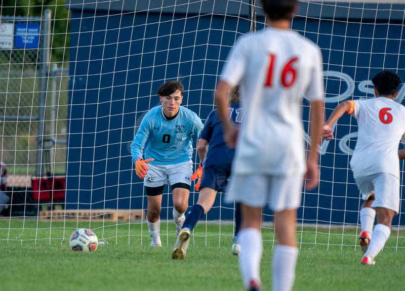 Oswego East's Adam Tobias (0) plays the ball in front of the net against Oswego during a soccer match at Oswego East High School on Monday, Sep 26, 2022.