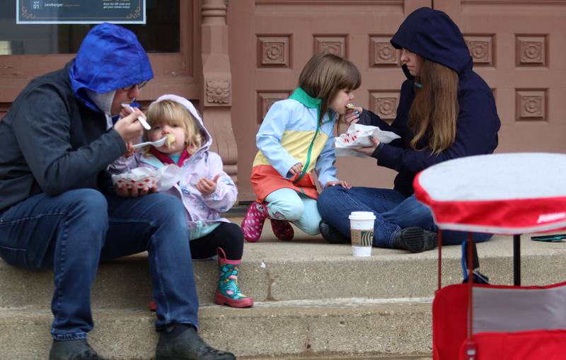 The Nickolas family of Woodstock munch on pierogis during the farmers market Saturday, April 29, 2023, on the historic Woodstock Square. From left, Kris and his daughters, Kinsley, 2, and Kalani, 4, and wife, Kiersten.