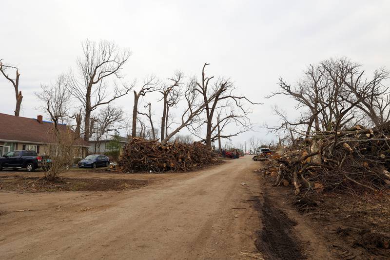 Debris is piled high along Oakwood Drive in Aroma Township on March 14, 2026, as crews worked to clean up following the March 10 tornado in Kankakee County.