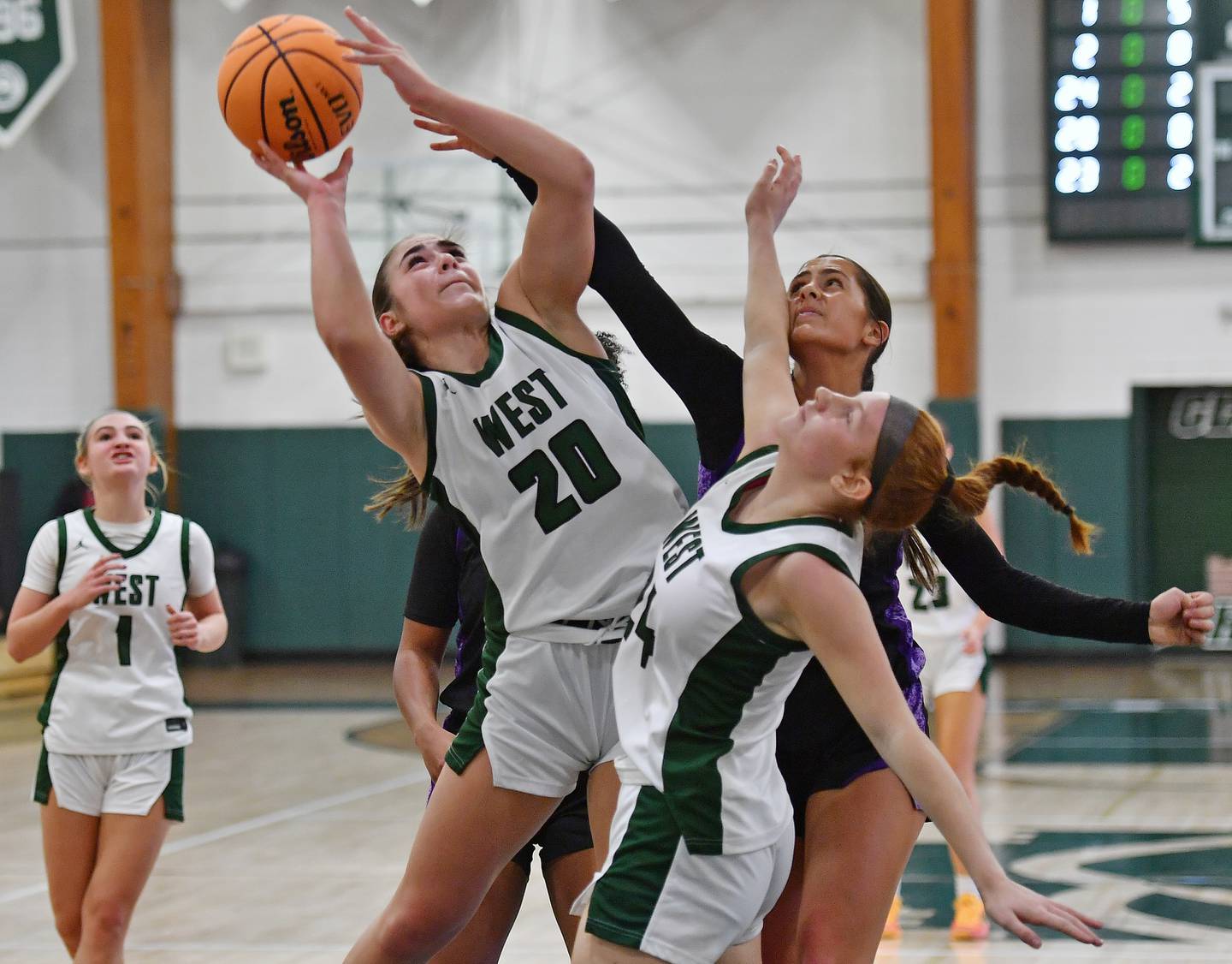 Glenbard West’s Ellie Noble (20) powers to the basket in a crowd during a game against Downers Grove North on December 4, 2025 at Glenbard West High School in Glen Ellyn.