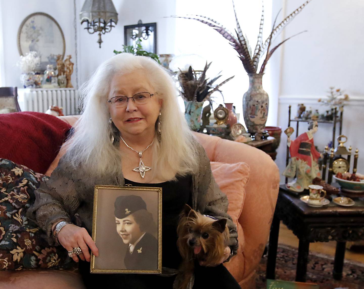 U.S. Navy veteran Donna Vestal holds a picture of herself when she was in the Navy at her home on Thursday, Oct. 17, 2024, in Crystal Lake.