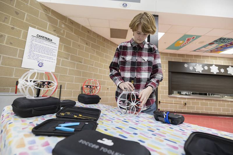 Ethan Boss, 15, tightens down the components Wednesday, Jan. 25, 2024. Along with learning to fly and the rules of the sport, club members need to build and maintain their own drones from standard kits.