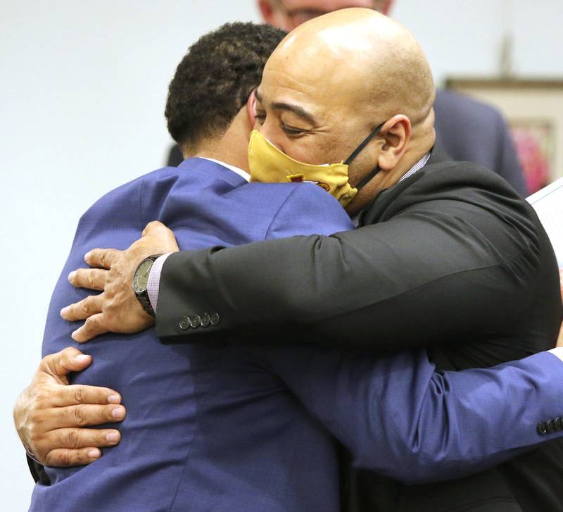 Illinois State Police Col. David Byrd, (right) who was named as the City of DeKalb's next police chief, hugs John Walker Monday at the DeKalb City Council meeting. Walker, who was a member of the police chief search committee,  was a strong advocate for the selection of Byrd.