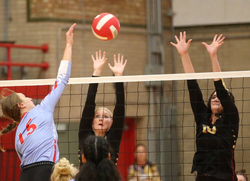 Ottawa's Addison Duggan spikes the ball past Morris's Meg Guth and teammate Aubrey Phillips on Tuesday, Sept. 12, 2023 in Kingman Gym at Ottawa High School.