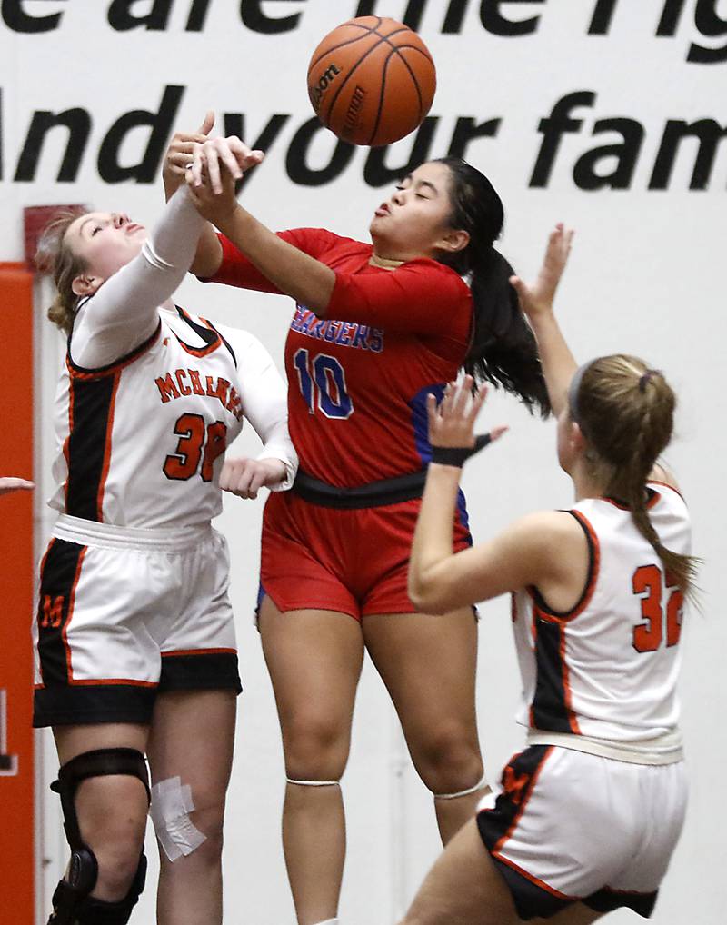 Dundee-Crown’s Theriz Mercado (center) tries to grab a rebound between McHenry's Ali Ahrens and Lucy Jones during a Fox Valley Conference girls basketball game on Tuesday, Dec. 12, 2023, at McHenry High School.