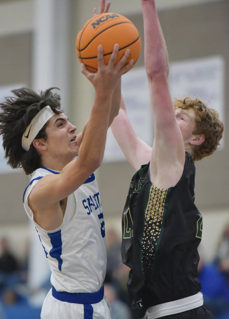 St. Francis’ Will Lyzun tries to shoot around St. Edward’s Kaden Dawson in a boys basketball game in Wheaton on Tuesday, December 6, 2022.