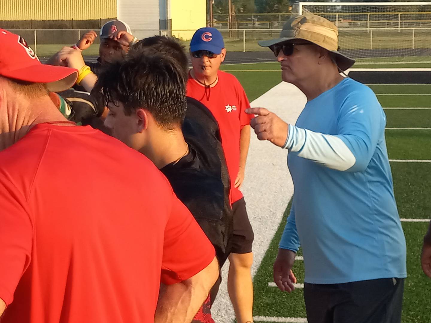 Bradley-Bourbonnais assistant and longtime Herscher head coach Dan Wetzel, right, participates in a huddle following a scrimmage at Herscher High School on July 22, 2025.
