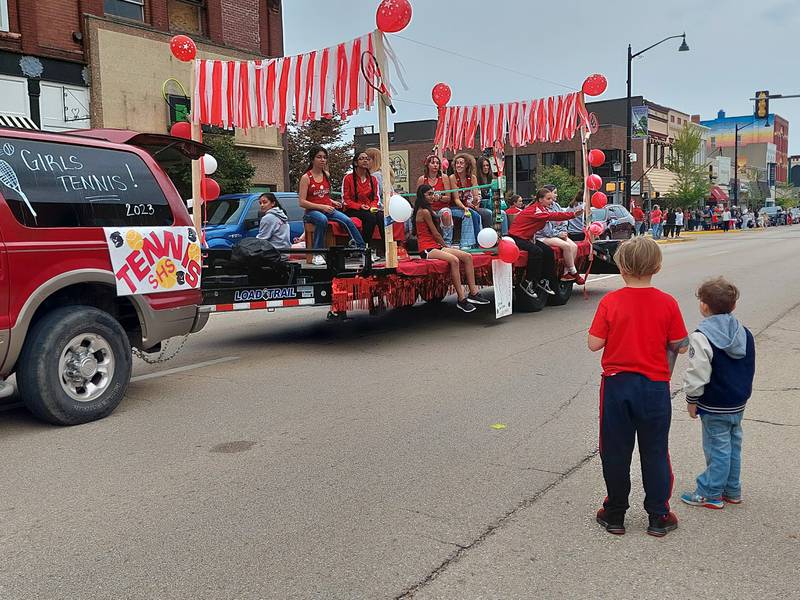 The Streator High School girls tennis team gets ready to toss candy Friday, Sept. 22, 2023, at some young homecoming parade attendees.