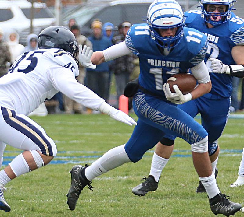 Princeton's Noah LaPorte (11) looks to stiff arm IC Catholic's Foley Calcagno (45) defends in the Class 3A Quarterfinal game on Saturday, Nov. 12, 2022 in Princeton.
