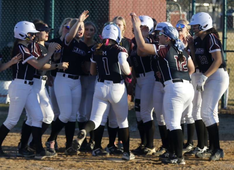 Marengo's Gabby Christopher is greeted by her teammates after hitting a home run during a nonconference softball game against Jacobs on Monday, March 9, 2026, at Marengo High School.