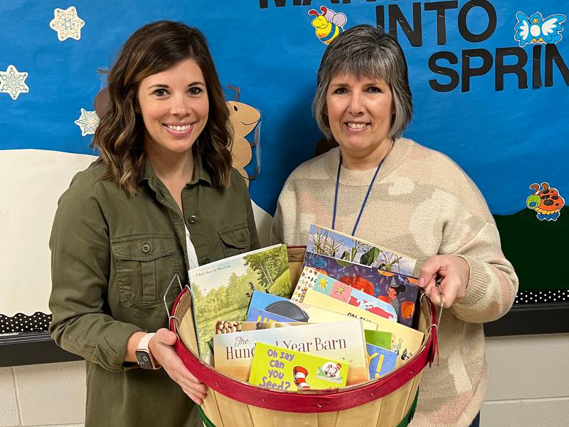 Preschool teachers Jessica Ortgiesen and Jen Wilkens accept the Books by the Bushel donation for Faith Christian Preschool.