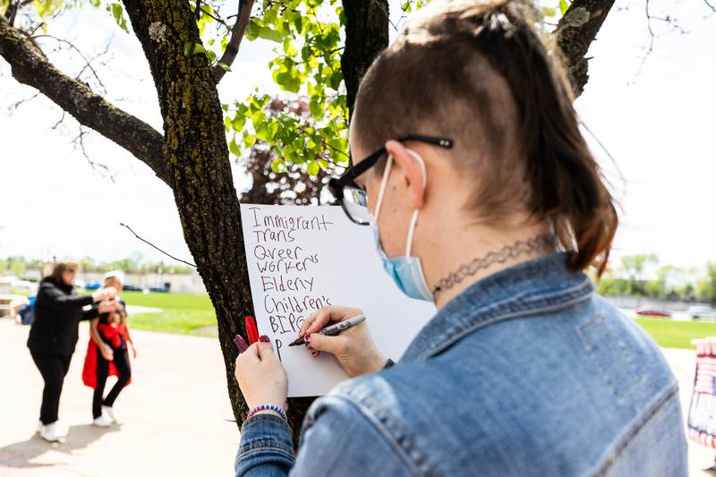 Kay Sullivan creates a new sign while attending the May Day Weekend Rally in Downtown Joliet on May 3, 2025.
