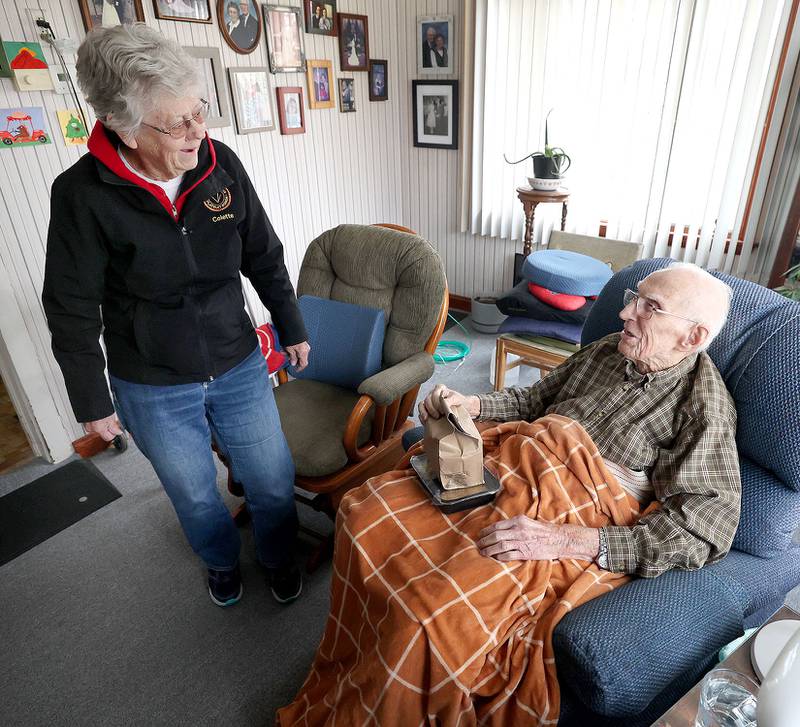 Colette Theurer, a driver with the Voluntary Action Center, chats with 102-year-old Wilbur Kocher after delivering his meal, Thursday, Nov. 17, 2022, at his home in Sycamore. VAC delivers meals to the homebound and elderly along with providing transportation options.