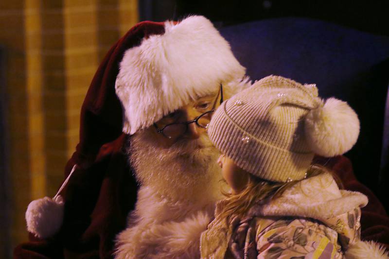 Santa Claus talks with q young girls during the Lighting of the Square Friday, Nov. 24, 2023, in Woodstock. The annual holiday season event featured brass music, caroling, free doughnuts and cider, food trucks, festive selfie stations and shopping.