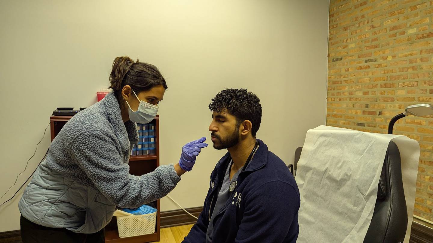 Amatullah Yousuf (left), a clinical research coordinator with Avicenna Clinical Research, stages a nasal swab with Adnan Adamji, (right), a medical assistant with Rapid Healthcare in Joliet on Thursday, Feb. 6, 2025. Yousuf performs clinical research on flu at the Rapid Healthcare site.