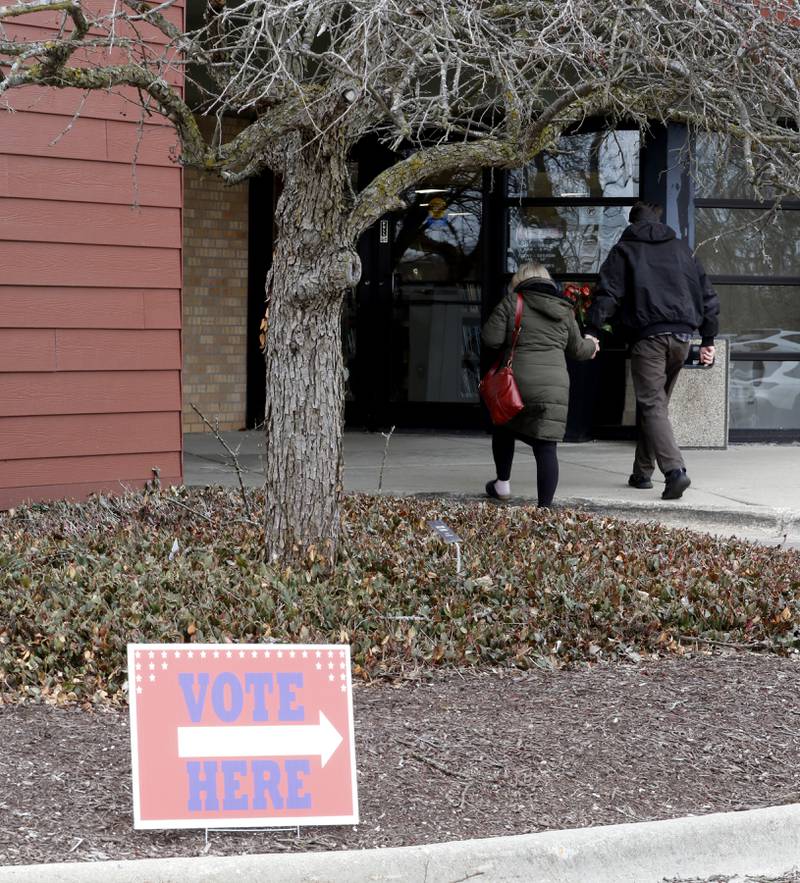 A couple holds hands as they walk into vote  at the Nippersink  Public Library in Richmond on Tuesday, April 1, 2025, in the 2025 Consolidated Election.