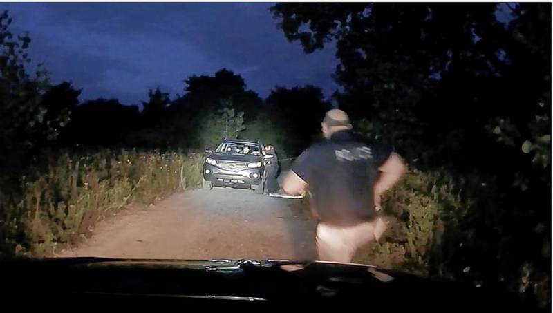 Lakemoor police officer Anthony Loiacono runs to the aid of fellow officer Briana Tedesco, who was struggling with Kenneth Martell over two guns he had produced in an SUV parked in a driveway off Four Seasons Road. Tedesco is suing the village of Lakemoor for wrongful termination because she was uncomfortable returning to work soon after the shooting.