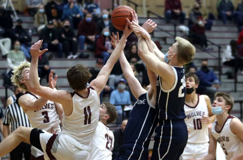 Prairie Ridge’s James Muse, left, and Cary-Grove’s Ryan Zielinski, right, are among a group struggling for a rebound during boys varsity basketball action in Crystal Lake Tuesday night.