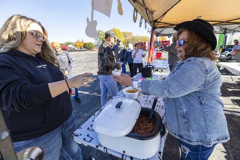 Cooking for Kreider, Rose Grygiel (right), hands Ashley McCrary a cup of chili Sunday, Oct. 22, 2023 at the Elks Club chili cookoff in Dixon.