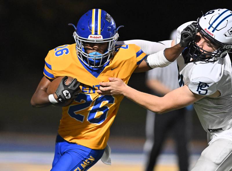 Joliet Central's Tra’vonte Nicks (26) stiff arms Plainfield South's defender during the conference game on Friday, OCT. 17, 2025, at Joliet.