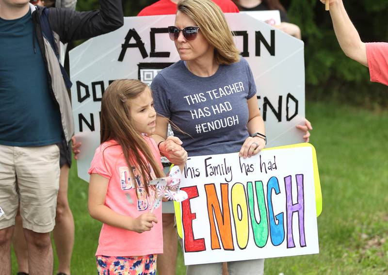 Jessica Nall, an employee of the DeKalb School District, and her daughter Charlie, 6, from DeKalb, protest Saturday, June 11, 2022, during a March For Our Lives event that kicked off at Hopkins Park in DeKalb. The March For Our Lives initiative advocates for, among other things, an end to gun violence, updated gun control legislation and policy targeting gun lobbyists.