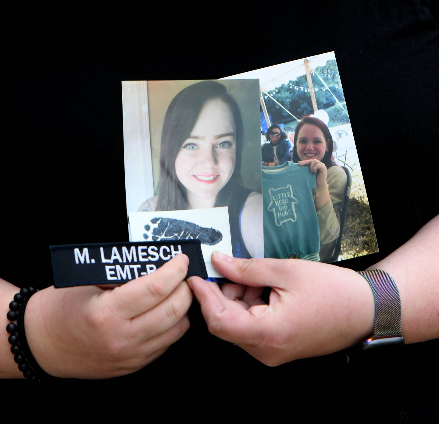 Rachel Sitkiewicz, an EMT who served with Melissa Lamesch, holds photos of Melissa and a footprint of Lamesch's unborn son after an April 29, 2022, court hearing.