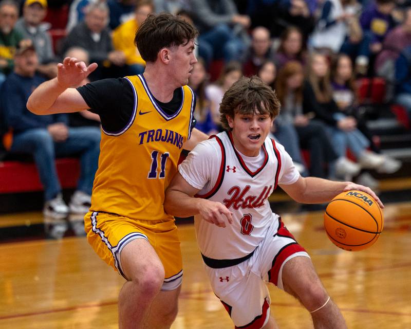 Greyson Bickett (0) of Hall drives ball in lane as Aden Tillman (11) of Mendota guards at hip on Saturday, December 20, 2025 at Hall High School in Spring Valley.