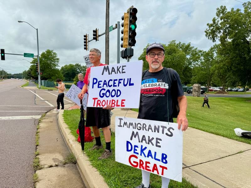 DeKalb resident Steve Kapitan (right) holds signs on Saturday, July 19, 2025, along Sycamore Road in Hopkins Park in DeKalb for a "Good Troubles Lives On" demonstration, one of thousands organized this week to honor the life and legacy of the late U.S. Rep. John Lewis. Though the official event was canceled due to weather Saturday, many still showed up to protest actions taken by President Donald Trump and his administration.