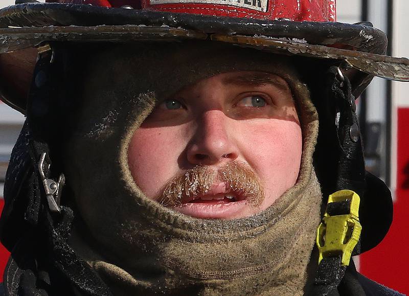 La Salle firefighter Hunter Thurman, face freezes while taking a break from fighting a fully engulfed house fire in the 800 block of Bucklin Street on Friday, Jan. 23, 2026 in La Salle.