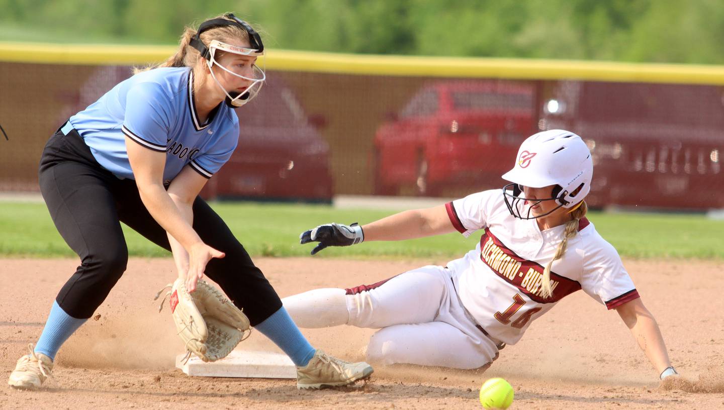 Richmond-Burton’s Taylor Davison slides safely into second base with a steal as Regina Dominican’s Ella Grillo fields the throw in Class 2A Regional title softball action at Richmond Friday night.