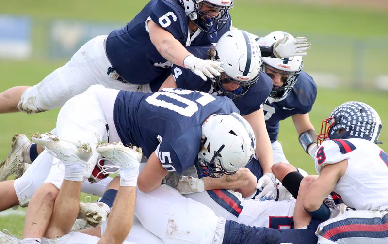 Cary-Grove’s Charlie Ciske, top, joins a pile of Trojans as they swarm a Belvidere North ballcarrier in IHSA Class 6A quarterfinal playoff football action on Saturday, Nov. 16, 2024, at Al Bohrer Field on the campus of Cary-Grove High School in Cary.