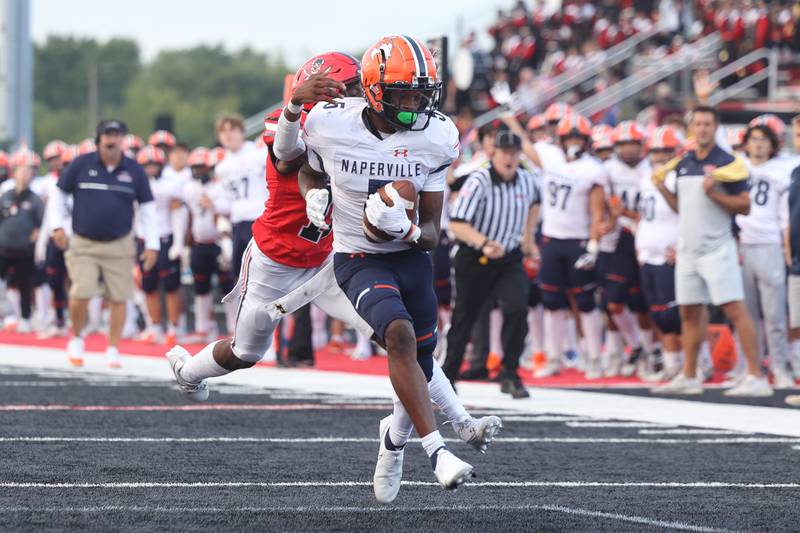Naperville North’s Luke Williams sheds a tackle for a touchdown against Bolingbrook on Friday, Sept. 8, 2023 in Bolingbrook.
