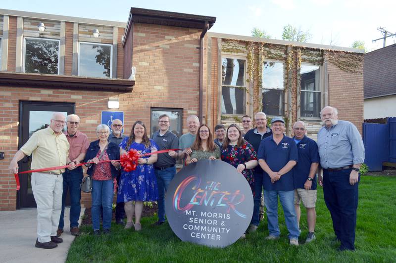 The senior center in Mt. Morris rebranded as the Mt. Morris Senior & Community Center with a ribbon-cutting on Tuesday, April 30, 2024. Left to right are: Jon Murray, Center Board vice president; Ed Baker, Center Board member; Kathy Heid, Center Board president; Bob Coulter, Oregon Area Chamber of Commerce Board member; Melissa Rojas, Center executive director and Mt. Morris Village Board trustee; Chance Munroe, Chamber executive director; Harvey Briggs, Center Board treasurer; Kris Wachs, Center director's assistant; Terry Schuster, Chamber Board member; Erica Nicholson, Center member; Rob Gieraltowski, Chamber Board member; Phil Labash, Village president; Morgan McConnell, Village trustee; Mike Fay, Village trustee; and Jeff Bold, Chamber Board member.