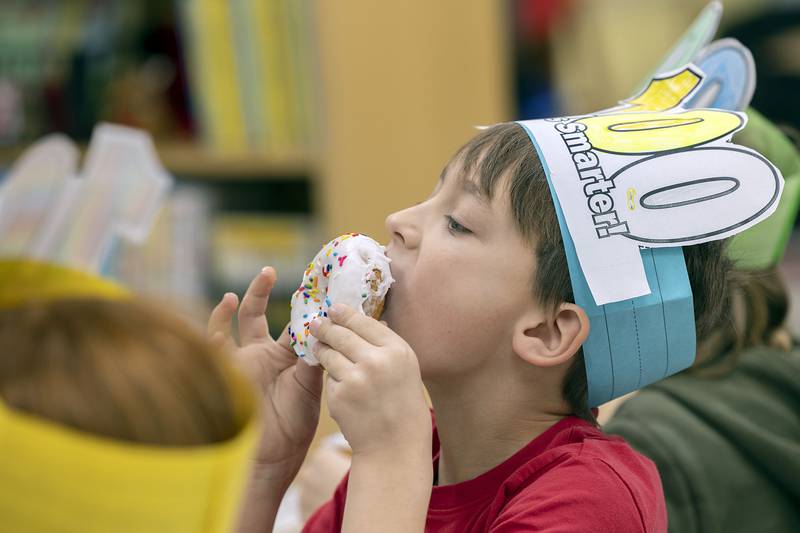 Dixon’s Jefferson School second grader Bennett Full digs into his doughnut as a 100the day class treat Thursday, Jan. 26, 2023.