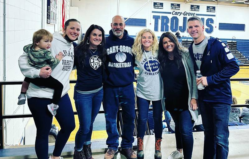 Cary-Grove athletic director Jim Altendorf (middle) has a picture with four of his former players at a recent Trojans girls basketball game. Altendorf is the former C-G girls coach. From left: Amy Kaplan Johnson (and daughter Camryn), Kendra Petrie Kulans, Altendorf, Krista Petrie Diehl, Anna Ashley Pierce and C-G assistant AD Tim Garis.