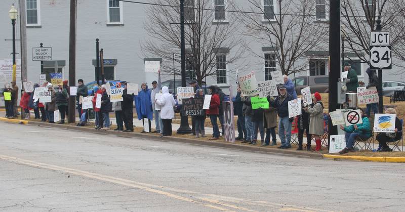 Dozens of citizens gather during a March 4 Democracy on Tuesday, March 4, 2025 at Rotary Park in Princeton. Participants brought signs to feature issues of concern for the county, state and country. The event was sponsored by concerned citizens of Bureau County.