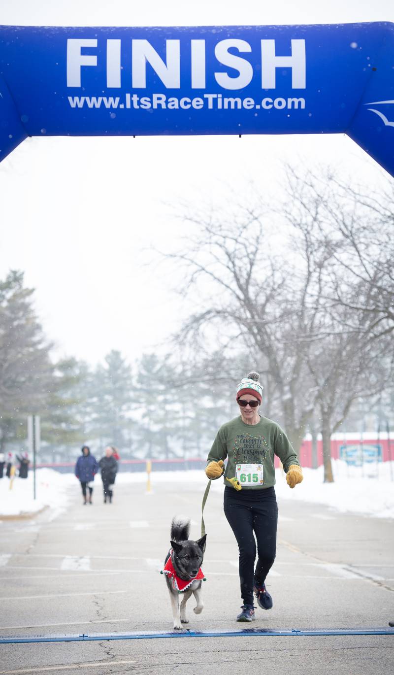 Meg Lumbrezer, of Bradley, finishes with her dog Gus in the  35th annual Jingle Bell Run at Kankakee Community College  on Sunday, December 7, 2025.